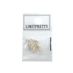 Sparkling bow nail art charms with white pearls and zircons in professional packaging