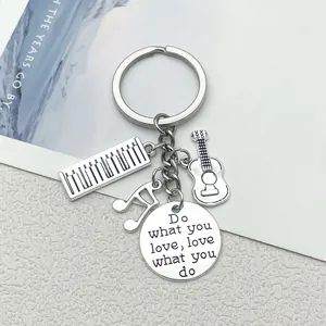 Macro detail of music theme keychain with piano and guitar charms and engraved quote