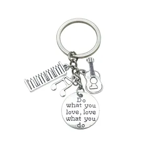 Detail view of music-themed keychain charms featuring guitar and engraved plate