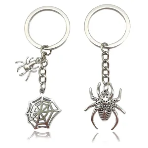 Detailed view of silver spider and spiderweb metal keychains for backpack charms