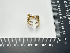 Detailed size measurement of a gold-plated multi-layer pearl open ring on a ruler.
