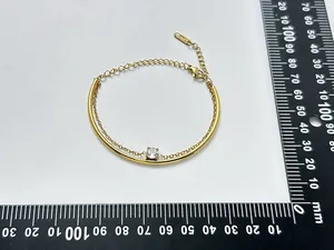 Detailed view of an 18K gold-plated stainless steel zircon bracelet measured on a scale.