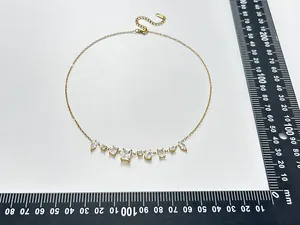 Detailed view of French retro gold plated necklace with geometric zircons and size ruler