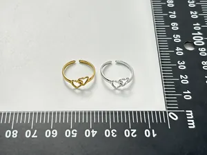 Double heart hollow stainless steel ring shown with a black ruler for size reference
