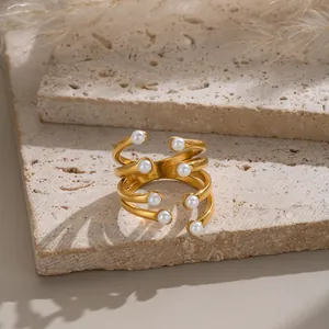 Detailed view of an elegant multi-layer gold-plated ring with small white pearls.