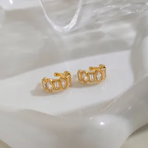 Detail view of geometric gold stainless steel ear cuffs with marquise and baguette CZ stones.