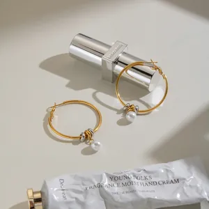 Close-up of 18K gold plated stainless steel hoop earrings with elegant pearl charms