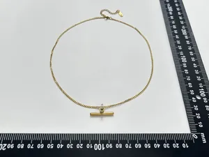 Detail view of gold T-bar pendant necklace showing size measurements in millimeters
