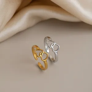 Detailed macro view of interlocking double heart rings in gold and silver finishes