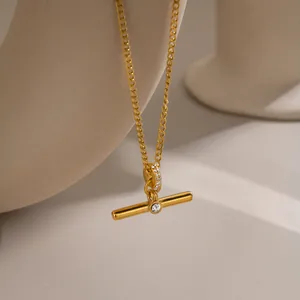 Macro detail of gold T-bar pendant necklace with sparkling crystal accents