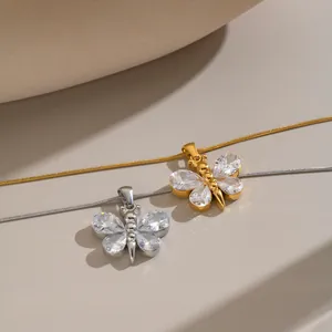 Close-up detail of butterfly zircon pendant necklaces in silver and 18K gold finish
