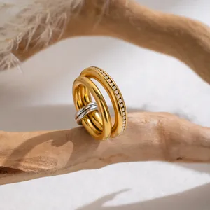 Nahaufnahme eines mehrschichtigen vergoldeten Edelstahlrings mit Kristallbesatz