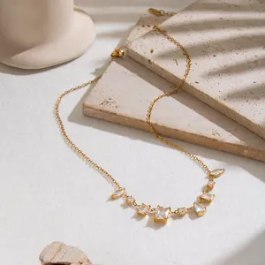 Detail view of vintage 18K gold plated necklace with geometric zircon charms on stone.
