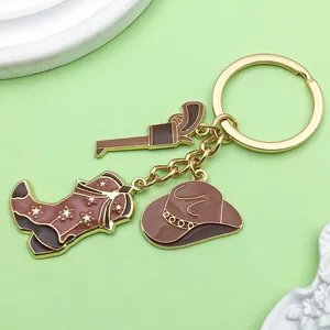 Détail du porte-clés cowboy occidental avec des breloques pistolet, botte et chapeau