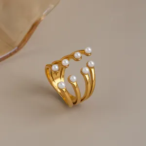 Detailed view of a multi-layer 18K gold-plated stainless steel ring with white pearls.