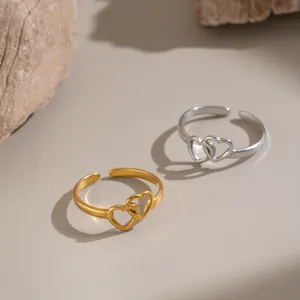 Detailed view of two interlocking heart stainless steel rings in gold and silver finish.