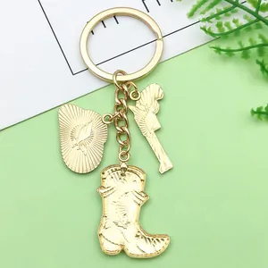 Gros plan du porte-clés cowboy doré avec des breloques de botte et de bouclier ailé