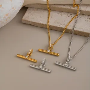 Detailed macro view of minimalist gold and silver T-bar pendants with crystal accents
