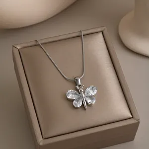 Close-up of a silver butterfly pendant necklace set with sparkling clear zircons
