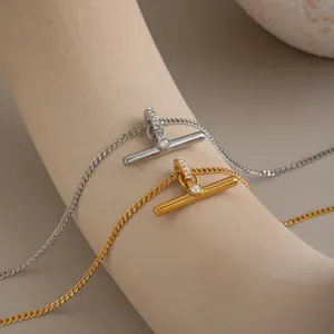 Close-up detail of gold and silver minimalist T-bar necklaces with sparkling rhinestone accents