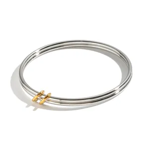 Brazalete de acero inoxidable de doble capa con detalles dorados en acabado plateado