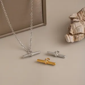 Detailed view of T-shaped zircon bar pendants in gold and silver stainless steel