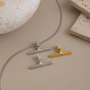 Detailed view of minimalist T-shape pendants in gold and silver finish with crystal inlay
