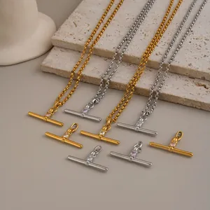 Detailed view of minimalist 18K gold and silver T-bar pendant necklaces with tiny zircon