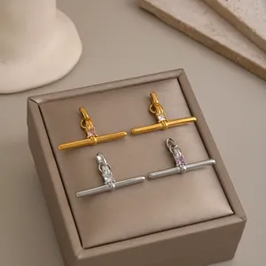 Detailed view of four T-shaped zircon pendants in gold and silver stainless steel