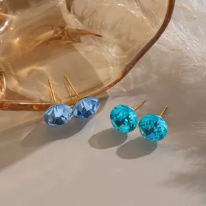 Close-up view of round colorful crystal stud earrings with gold-plated stainless steel posts.