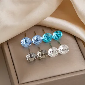Close-up view of faceted crystal glass stud earrings in multiple colors on jewelry box