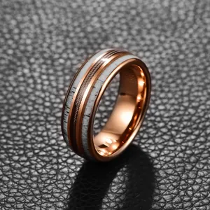 Close-up detail of a men's rose gold tungsten ring with antler and steel wire inlay.