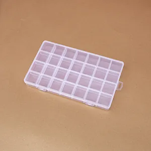Detailed view of a transparent 28-grid plastic storage box for jewelry and beads