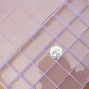 Macro detail of a 28-grid fixed transparent plastic storage box for jewelry and beads