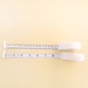 Detailed view of white Y-shaped retractable tape measure with dual cm and inch scales