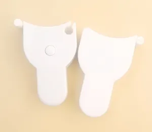 Detailed view of two white Y-shaped ergonomic body measuring tapes on plain background