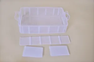 Macro detail of transparent plastic storage box showing removable dividers and handles