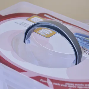 Detalle del asa de transporte gris de un organizador de tres capas en plástico transparente