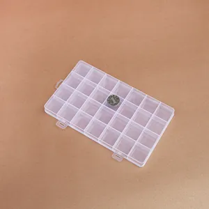 Detailed view of 28-grid clear plastic storage box with a coin for size reference