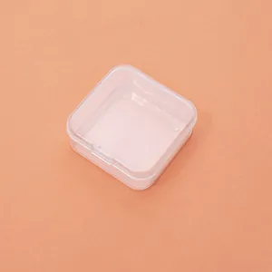 Close-up view of a clear square plastic storage box with a hinged lid for jewelry items.