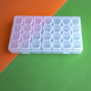Detalle de una caja de almacenamiento transparente de 28 rejillas para diamantes.