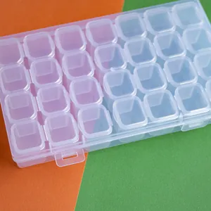Primer plano de caja de plástico transparente de 28 compartimentos para cuentas