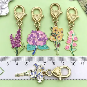 Macro view of 5 colorful floral enamel charms with heart clasps and measurement ruler.