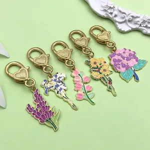 Detail view of five colorful enamel flower keychains with gold heart-shaped clasps.