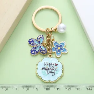 Detailaufnahme vom Muttertags-Schlüsselanhänger mit Emaille-Schmetterling und blauer Blume