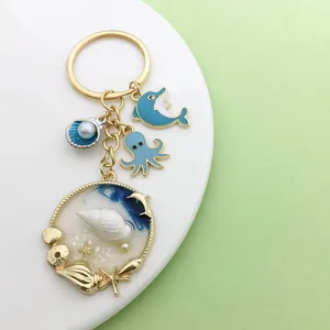 Detail view of ocean themed keychain charms including a blue octopus and seashell pendant.