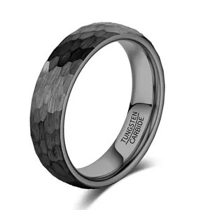 Macro view showing the faceted hammered texture of a black tungsten carbide wedding band