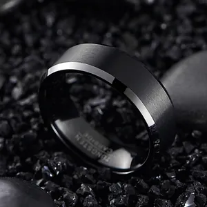 Macro detail of a black tungsten steel ring with silver beveled edges and matte finish.