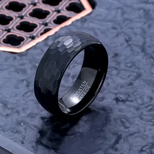Macro detail of a black hammered tungsten carbide ring with engraved interior text