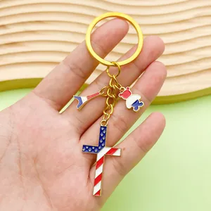 Close-up of USA flag themed cross and charms on a gold-tone memorial keychain gift